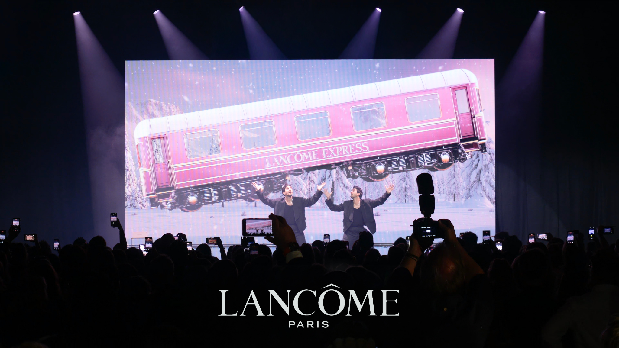 A luxury brand stage activation with a single performer at the centre of a softly lit room.