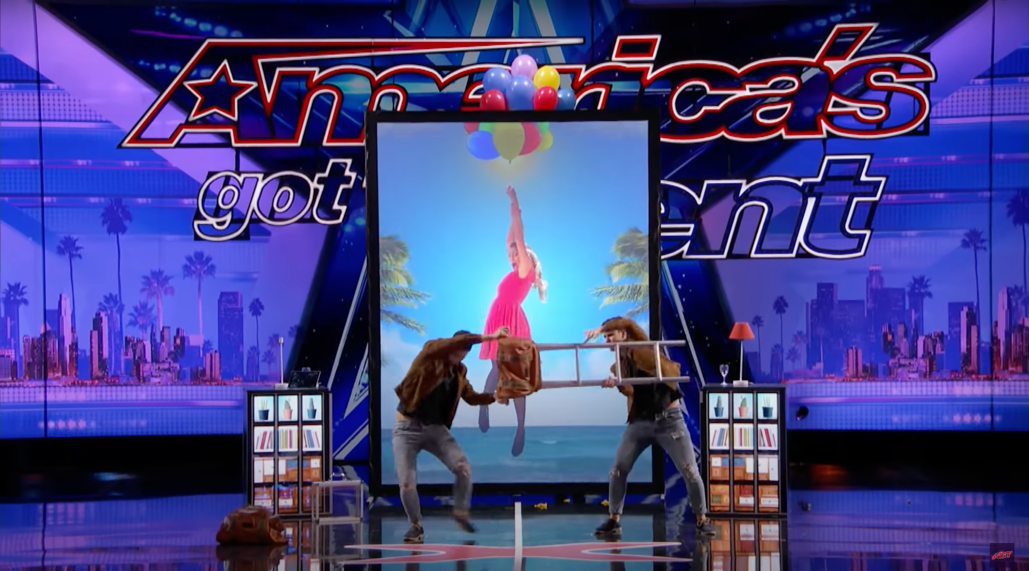 The duo extracting a woman from a stage LED screen at a private corporate event.